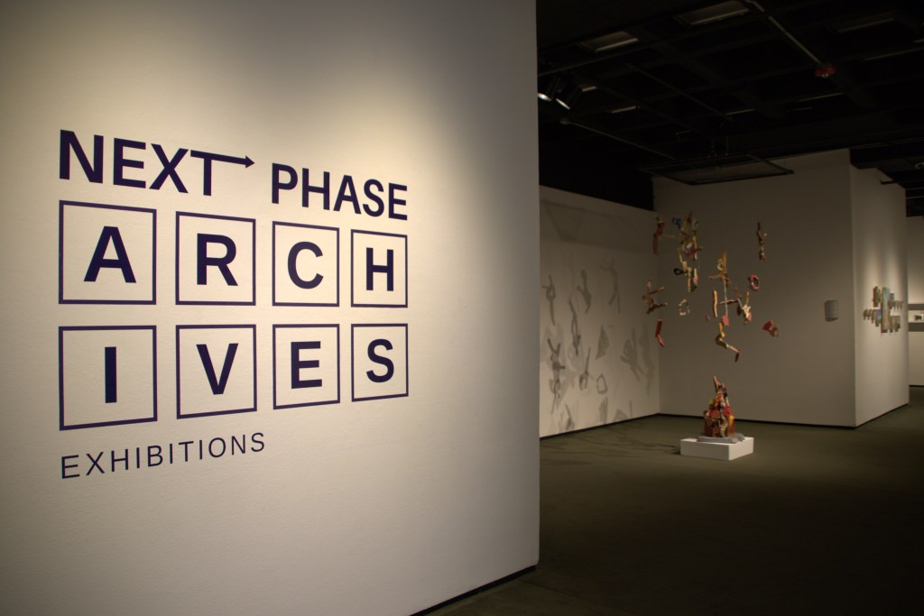 Photograph depicting the entrance area for ARCHIVES Exhibition's Next Phase exhibition, featuring the installation work of mid-career artist, Julie Glass that was developed through collaborative workshops and lectures