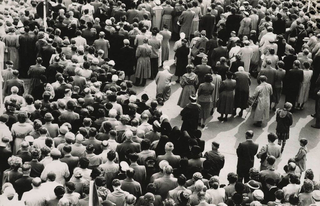 Black and white potograph depicting crowded public space
